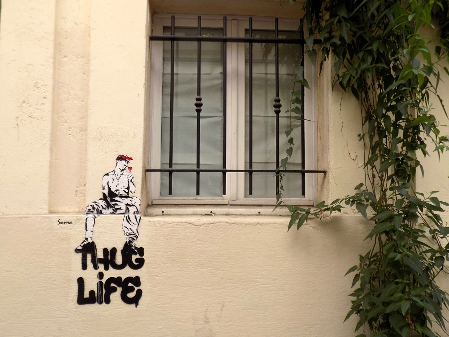 graffiti thug life et collage homme torse nu assis avec bandana rouge